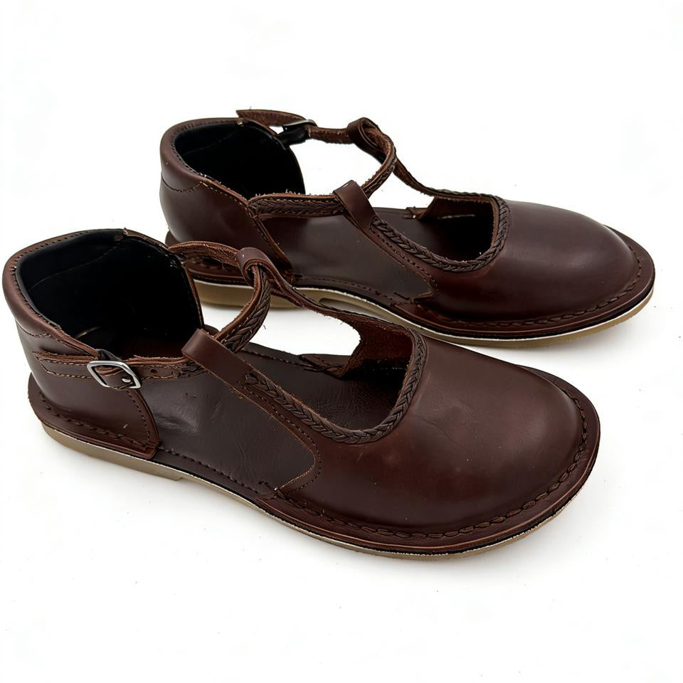Pair of brown leather shoes with T-straps on a white background