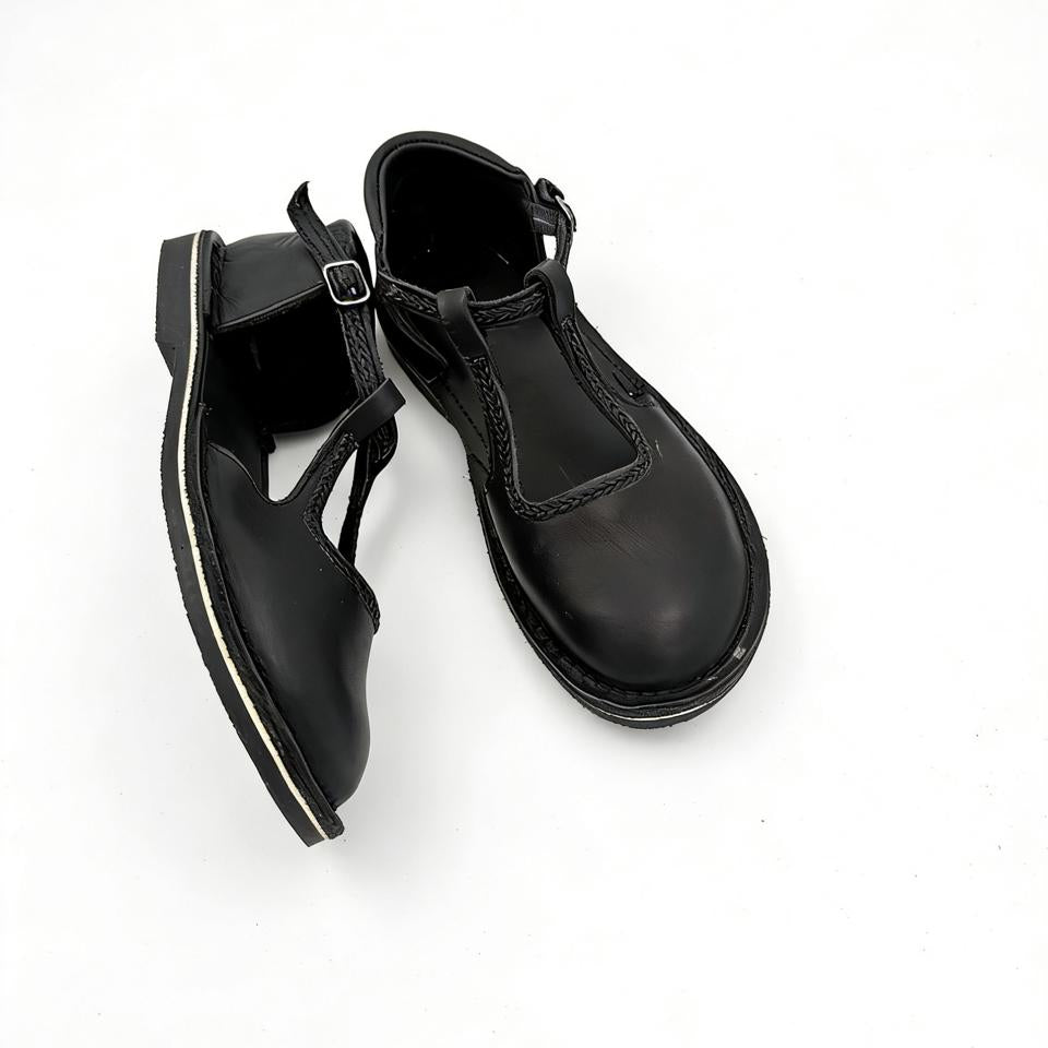 Black leather shoes with buckles on a white background